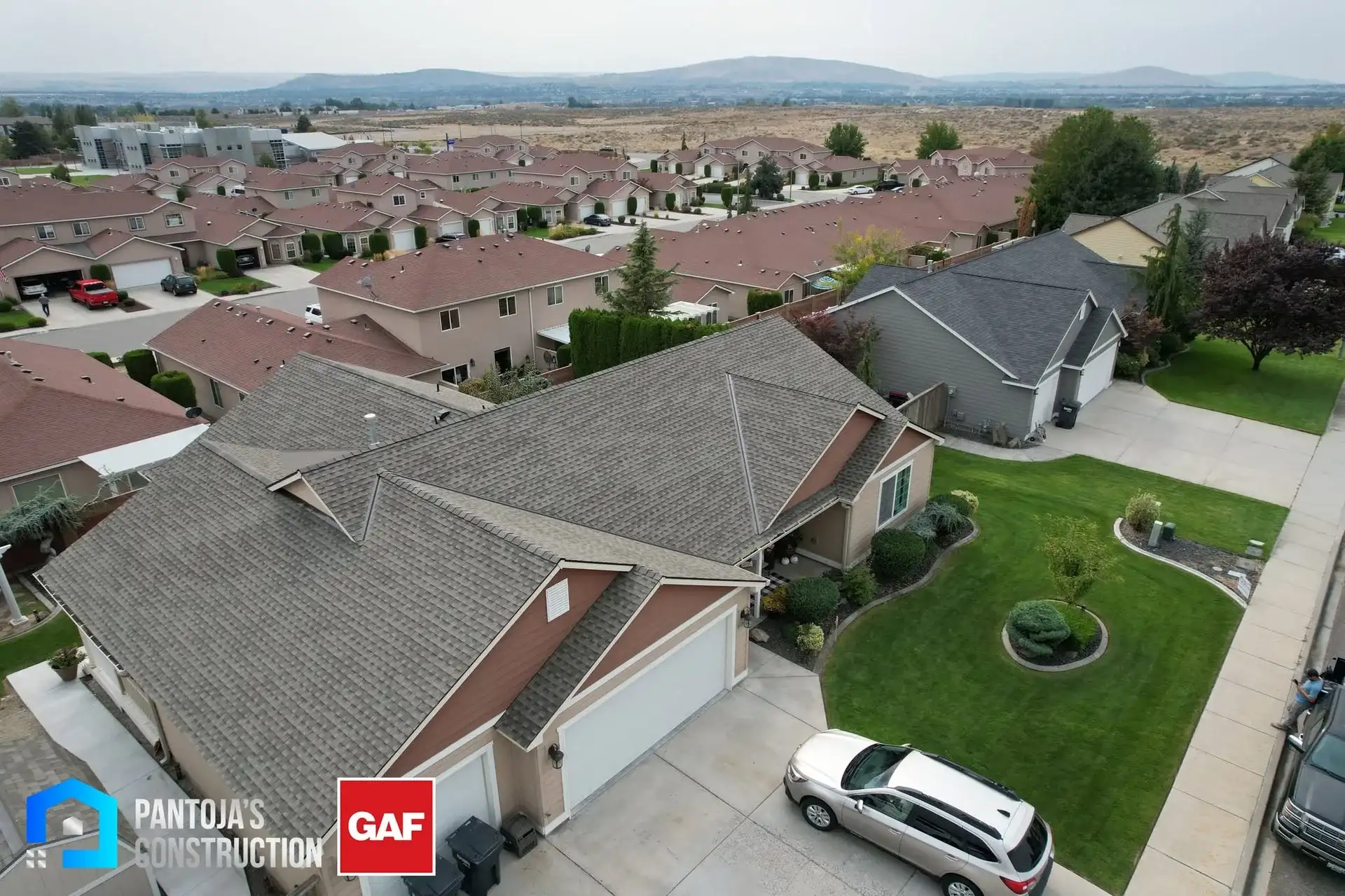 Home with a new GAF shingle roof installed by Pantoja's Construction, the neighborhood behind it